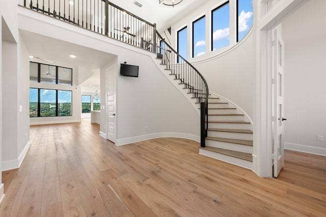 stairway with a towering ceiling and hardwood / wood-style flooring