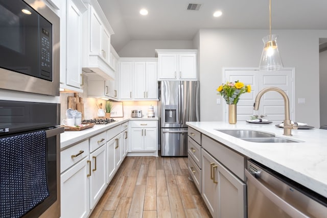 2131 Thayer Cv, San Antonio, TX 78253 - kitchen featuring appliances with stainless steel finishes, light wood finished floors, white cabinetry, recessed lighting, and pendant lighting