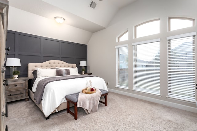 bedroom with light carpet and lofted ceiling