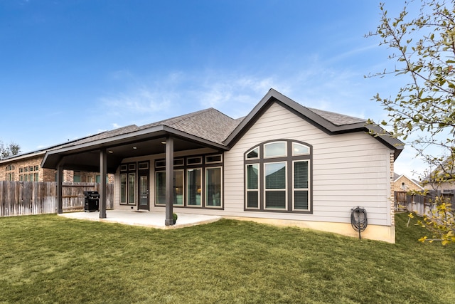 rear view of house featuring a patio area and a yard