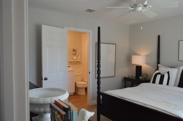 bedroom featuring light wood-type flooring, ceiling fan, and ensuite bath