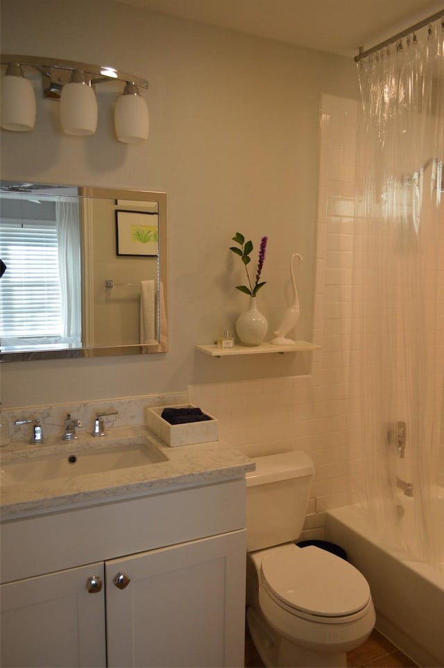 full bathroom featuring toilet, vanity, and shower / tub combo with curtain