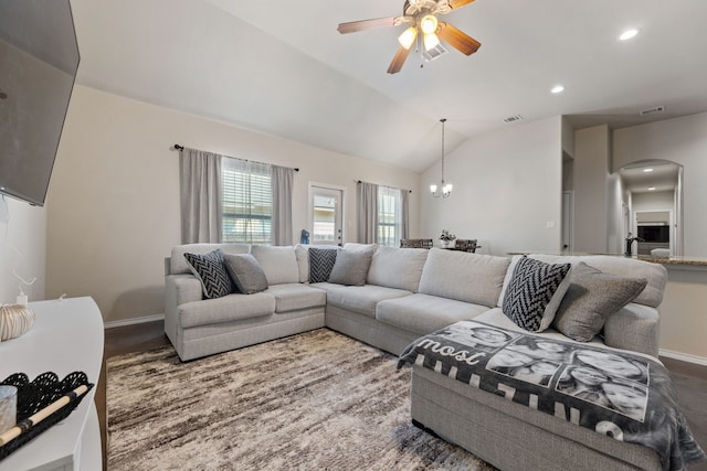 living room with lofted ceiling and ceiling fan with notable chandelier