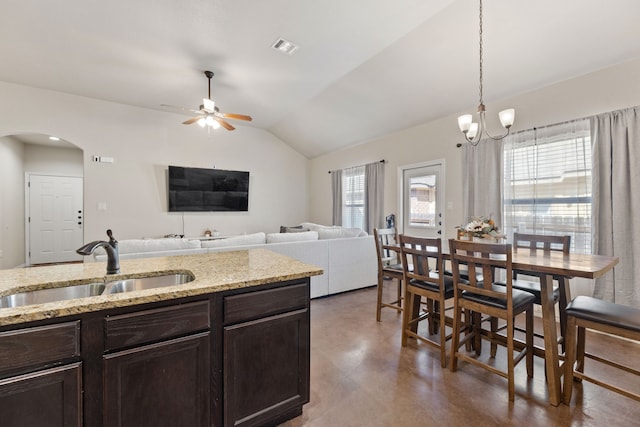 kitchen with vaulted ceiling, sink, plenty of natural light, and light stone countertops