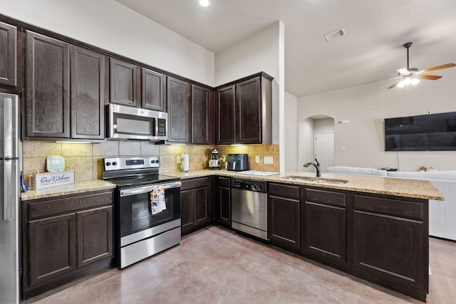 kitchen featuring kitchen peninsula, appliances with stainless steel finishes, tasteful backsplash, dark brown cabinetry, and sink