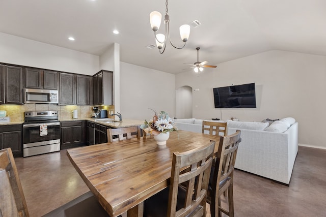 dining area featuring lofted ceiling, sink, and ceiling fan with notable chandelier