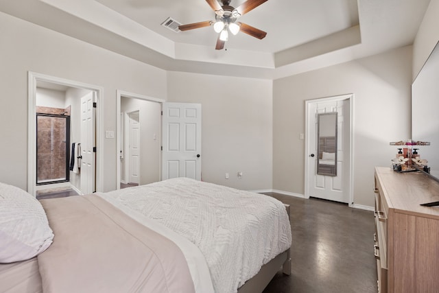 bedroom with ceiling fan, ensuite bathroom, and a raised ceiling