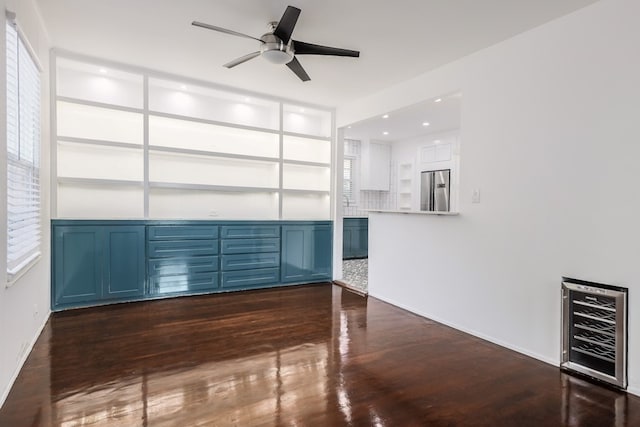 unfurnished living room featuring ceiling fan, dark hardwood / wood-style floors, built in features, and wine cooler