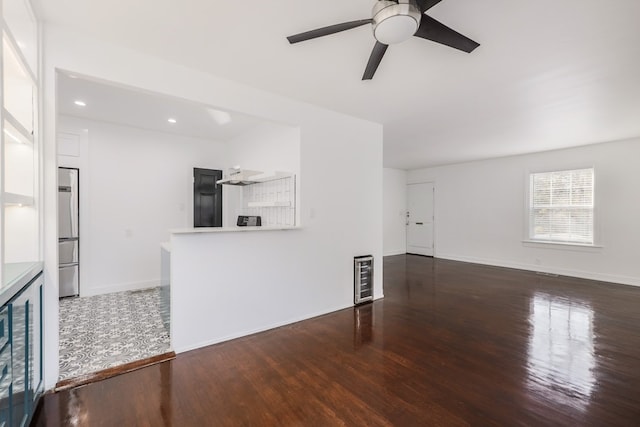 unfurnished living room with ceiling fan and dark hardwood / wood-style floors