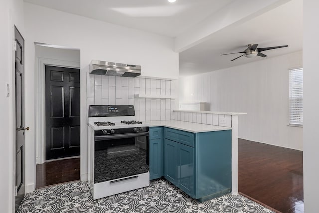 kitchen featuring range with gas cooktop, blue cabinetry, backsplash, kitchen peninsula, and ceiling fan