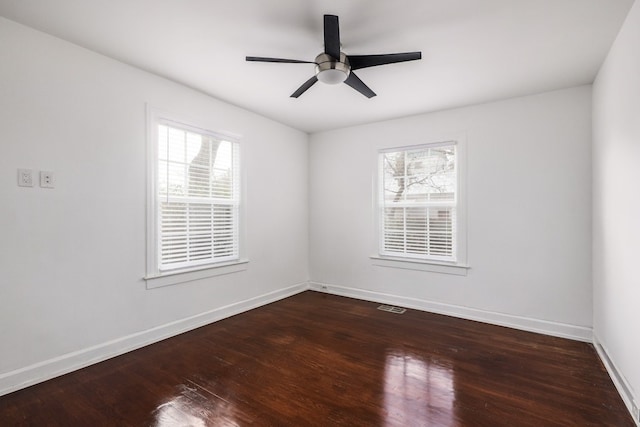 empty room with ceiling fan and dark wood-type flooring