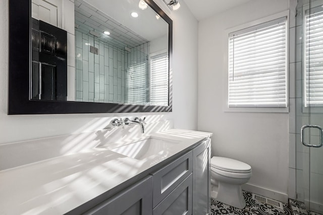 bathroom with toilet, vanity, tile patterned floors, and a shower with shower door