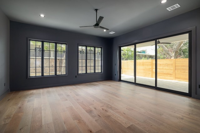 empty room with ceiling fan and light hardwood / wood-style floors