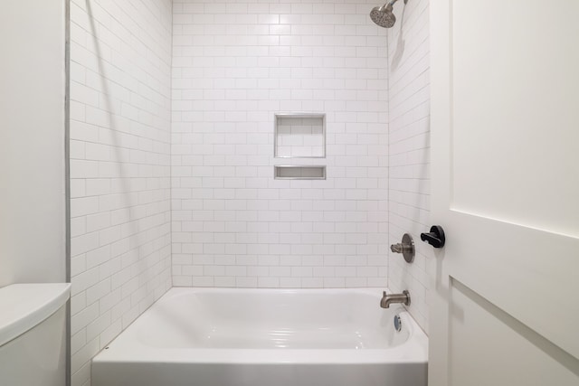 bathroom featuring toilet and tiled shower / bath combo