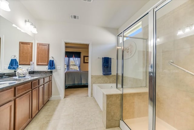 bathroom with visible vents, ensuite bathroom, tile patterned flooring, a shower stall, and a sink