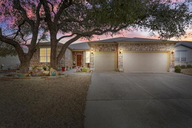 single story home with a garage, driveway, and brick siding