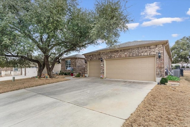 ranch-style home with central AC unit, concrete driveway, brick siding, and an attached garage