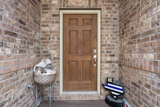 view of exterior entry with brick siding