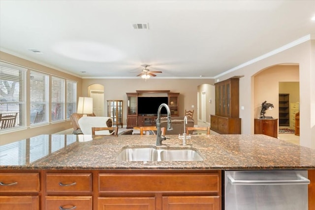 kitchen featuring dark stone countertops, open floor plan, and a sink