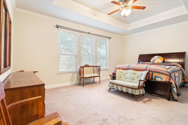 bedroom featuring light carpet, a tray ceiling, ornamental molding, and baseboards