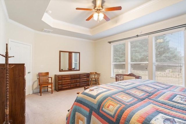 bedroom featuring light carpet, a ceiling fan, visible vents, a tray ceiling, and crown molding