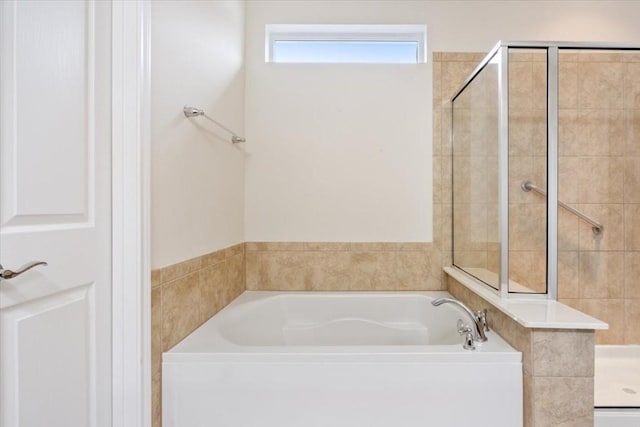 full bathroom featuring a garden tub and a shower stall