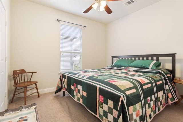 carpeted bedroom featuring a ceiling fan, visible vents, and baseboards