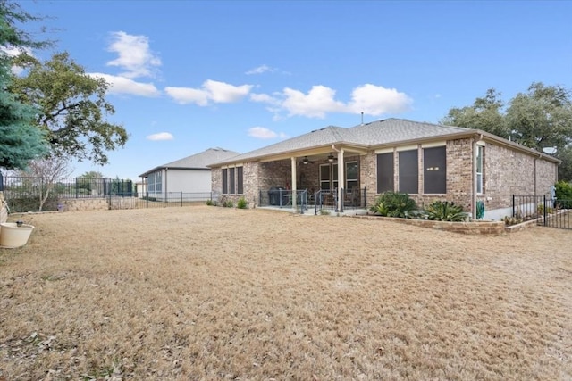 rear view of house with a fenced backyard and brick siding