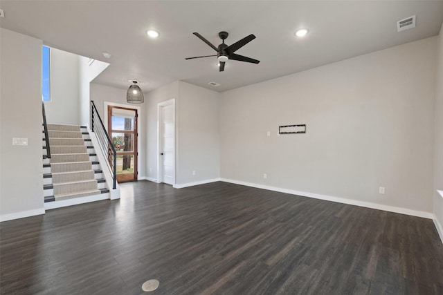 unfurnished living room featuring ceiling fan and dark wood-type flooring