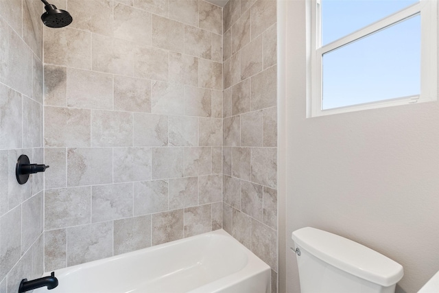 bathroom featuring toilet and tiled shower / bath combo