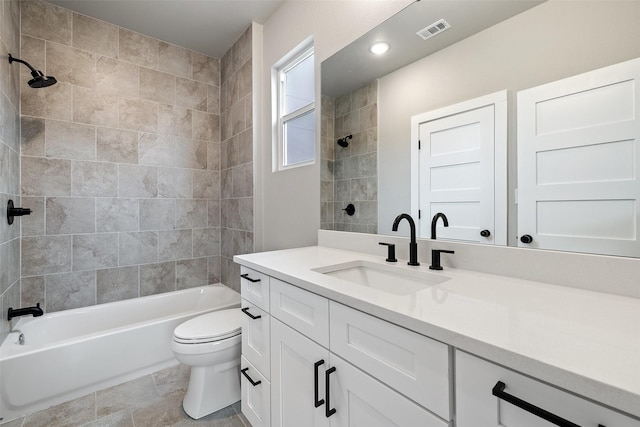 full bathroom featuring toilet, tiled shower / bath, and vanity