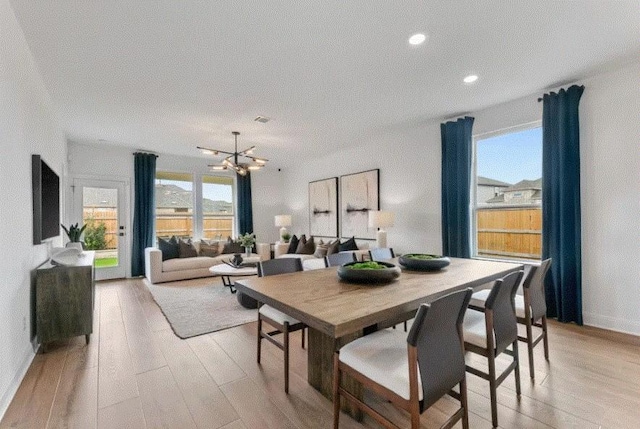 dining area featuring an inviting chandelier and light hardwood / wood-style flooring