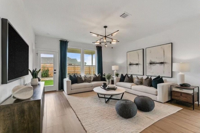 living room with hardwood / wood-style floors, a textured ceiling, and a chandelier