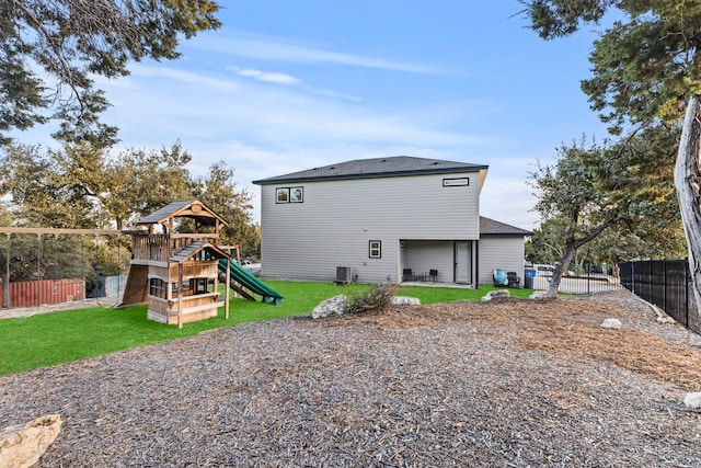 back of property with a playground, cooling unit, and a yard