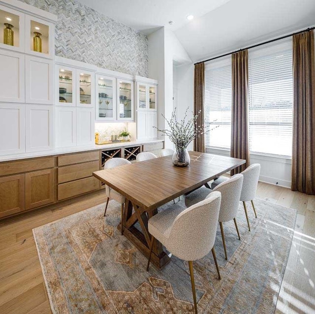 dining room featuring light hardwood / wood-style flooring and vaulted ceiling