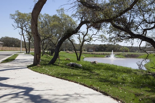 surrounding community featuring a lawn and a water view