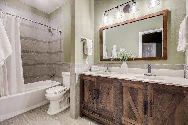 full bathroom featuring shower / bathtub combination with curtain, tile patterned flooring, tile walls, vanity, and toilet