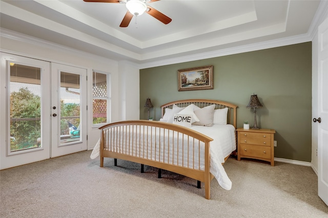 bedroom with ceiling fan, carpet, access to outside, a tray ceiling, and french doors