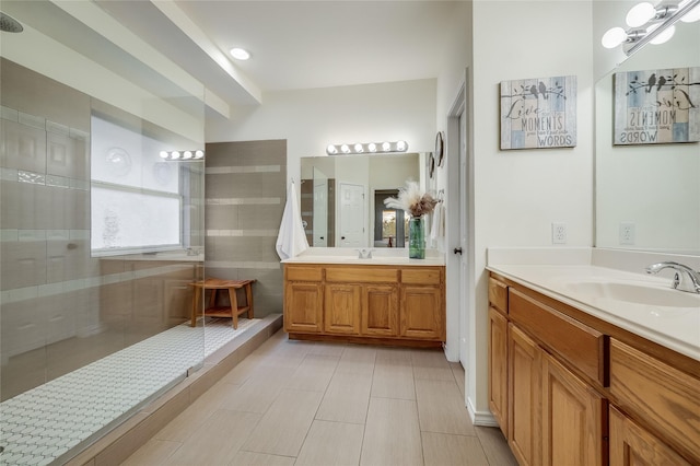 bathroom with tiled shower and vanity