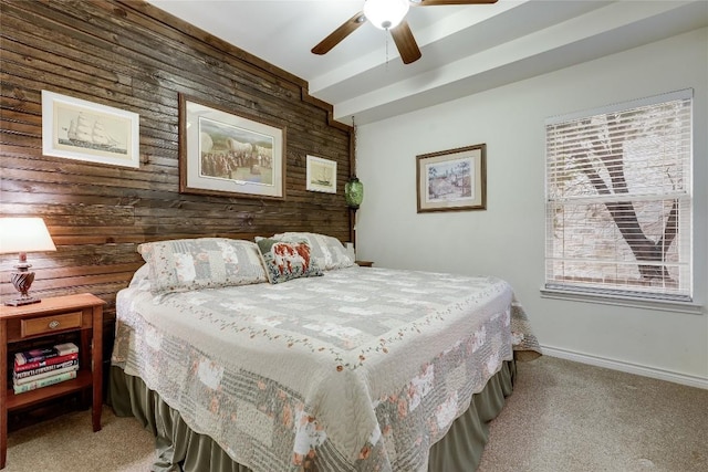 carpeted bedroom featuring ceiling fan and wood walls