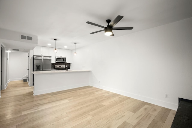 unfurnished living room featuring ceiling fan and light wood-type flooring