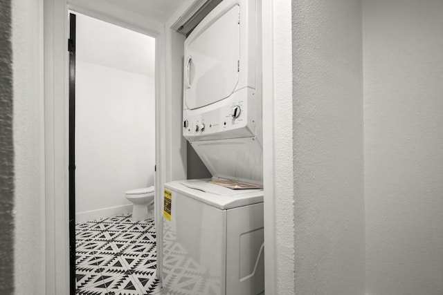 909 Reinli St Unit 103, Austin, TX 78751 - laundry area featuring stacked washer / dryer, tile patterned floors, and a textured wall
