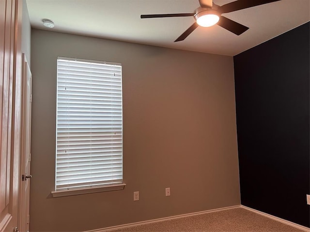 carpeted spare room with ceiling fan