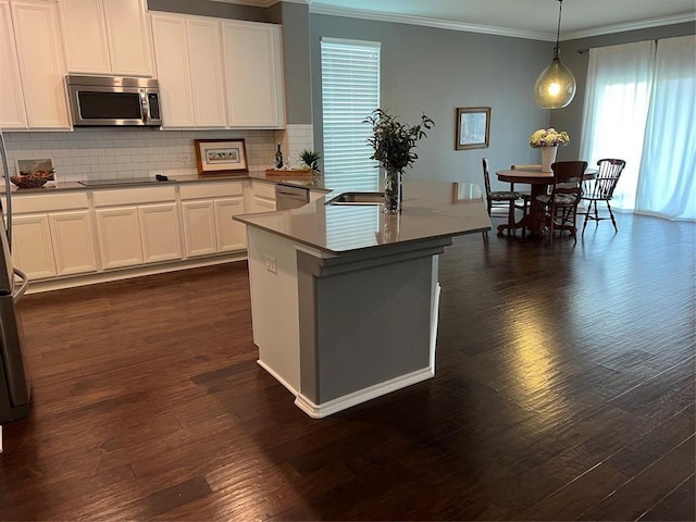 kitchen featuring pendant lighting, white cabinets, appliances with stainless steel finishes, tasteful backsplash, and dark hardwood / wood-style floors