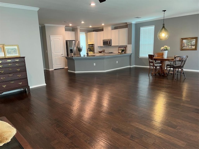 kitchen featuring decorative light fixtures, backsplash, dark wood-type flooring, stainless steel appliances, and white cabinets