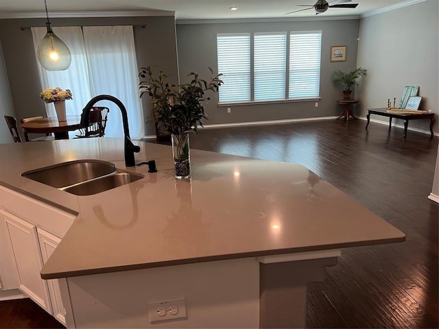 kitchen with pendant lighting, white cabinetry, sink, ornamental molding, and ceiling fan