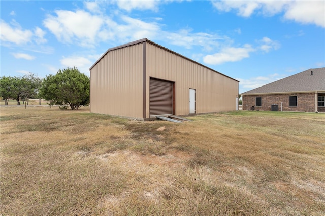 view of outdoor structure with central AC unit and a yard