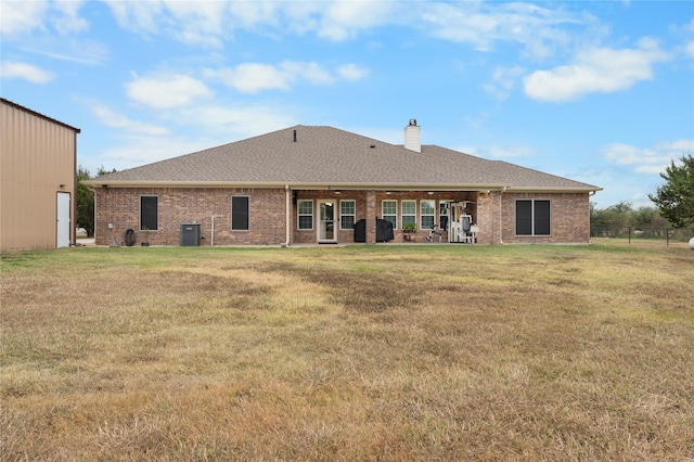 back of house with a lawn and central air condition unit