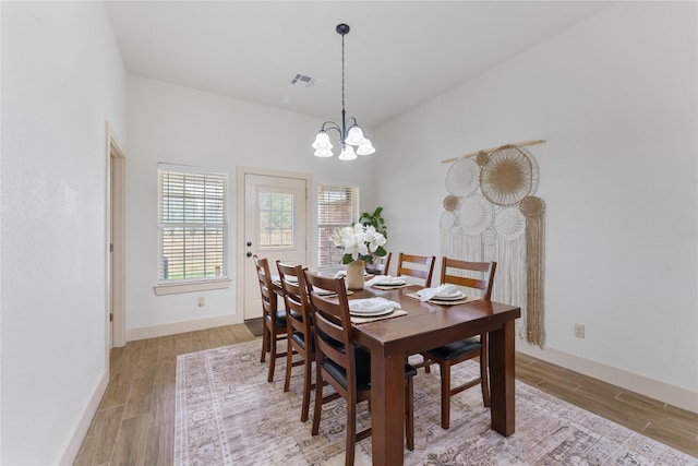 dining space with a notable chandelier and light hardwood / wood-style floors