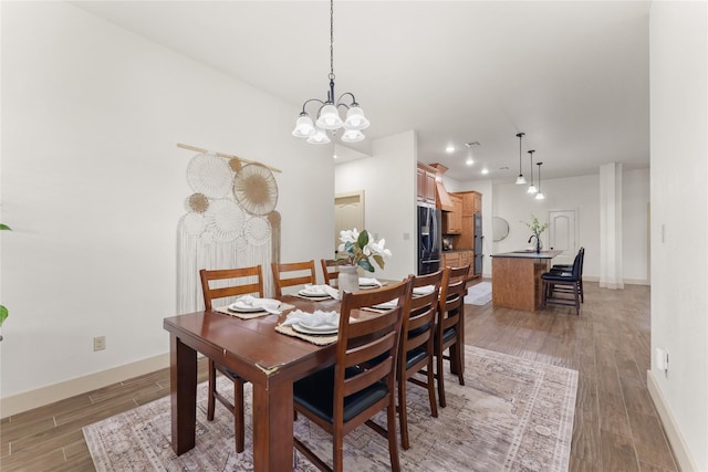 dining area with dark hardwood / wood-style flooring and a notable chandelier